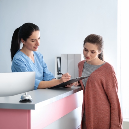 Dentistry team member and patient discussing the cost of dental implants