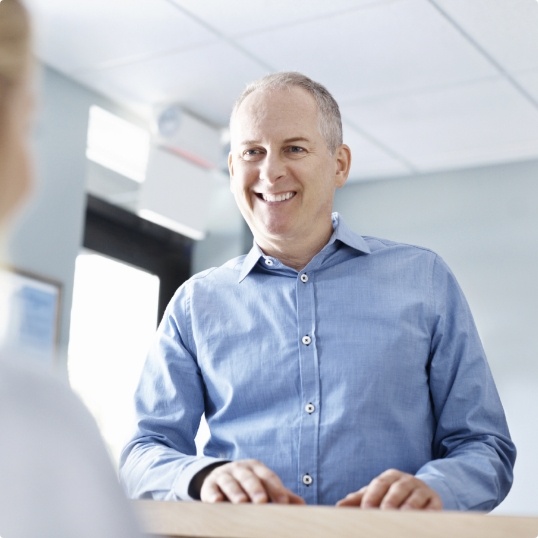 Man discussing how dental insurance works with dentist