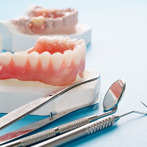 A closeup of denture models against a blue background