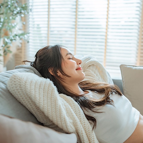 Woman resting at home on her sofa