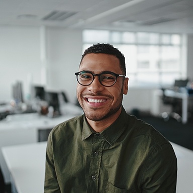 a smiling businessman sitting on a desk
