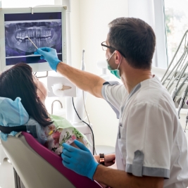 Dentist and dentistry patient looking at digital dental x rays