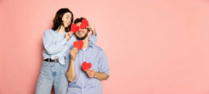 Happy couple holding red hearts
